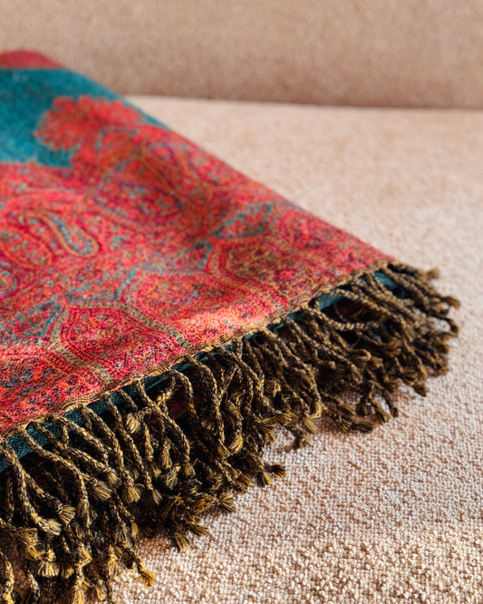 Dettaglio delle frange ritorte e del bordo paisley rosso corallo