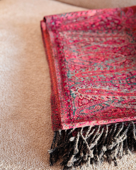 Coperta paisley arancio rame e fucsia piegata, vista dall'alto