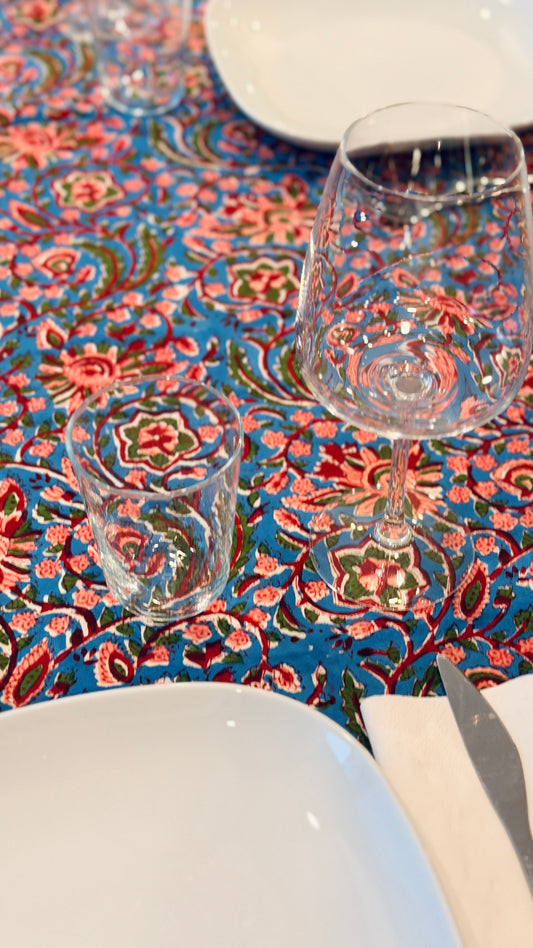 Hand-printed bright turquoise block print cotton tablecloth 150x220cm (60x87 inches): dense floral pattern in coral and red with a striped blue and white border.