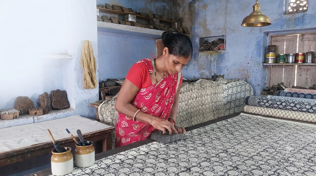 Artigiana indiana in sari rosso stampa a mano il cotone con blocchi di legno in un laboratorio block print