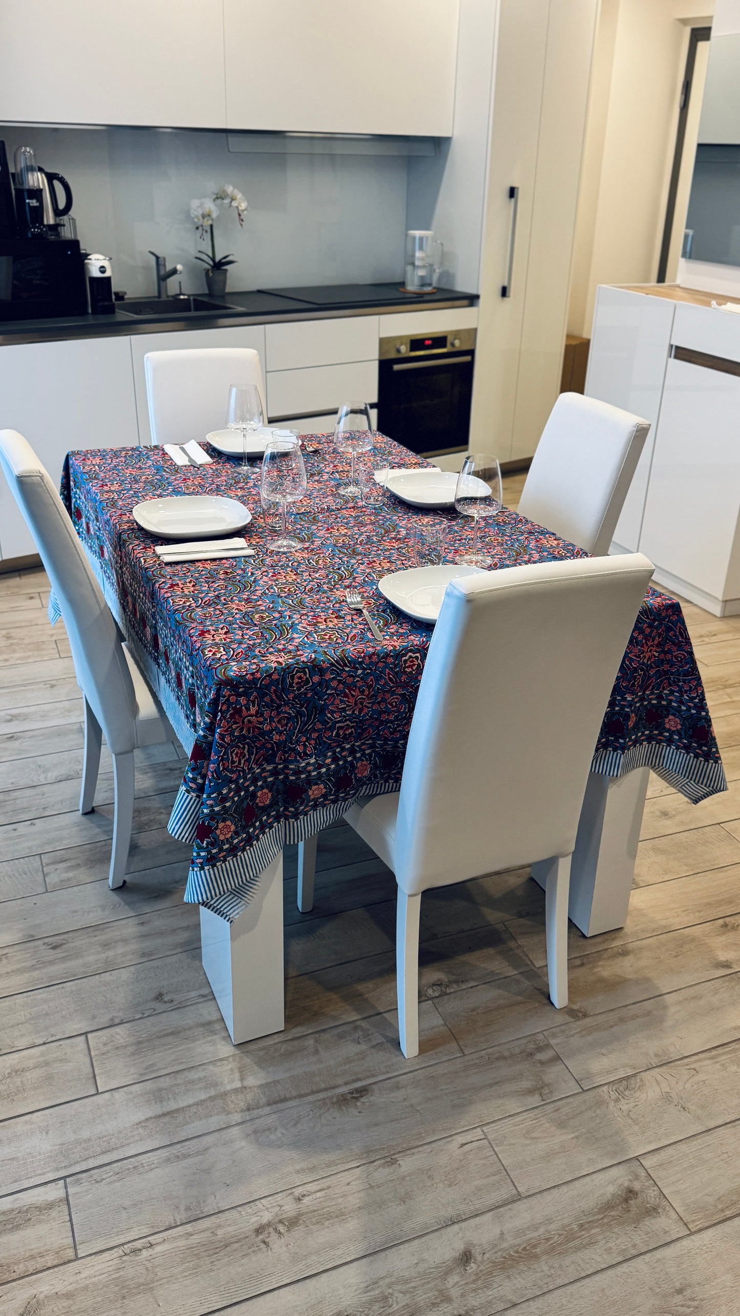 Hand-printed bright turquoise block print cotton tablecloth 150x220cm (60x87 inches): dense floral pattern in coral and red with a striped blue and white border.