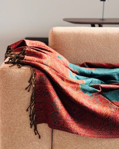 Coperta in lana jacquard paisley drappeggiata sul bracciolo, con frange