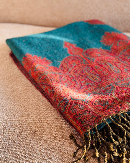 Coperta in lana piegata, bordo paisley in jacquard su fondo verde petrolio