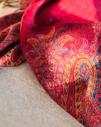 Dettaglio di un grande motivo paisley oro sulla coperta in lana rossa