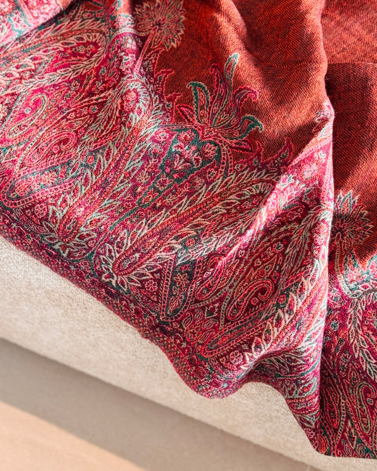 Bordo paisley fucsia in jacquard sulla coperta in lana, appoggiata sul divano
