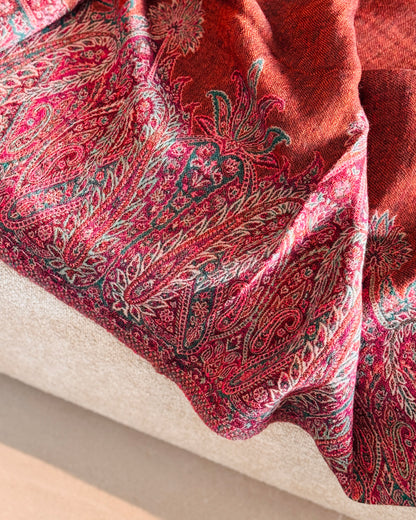 Bordo paisley fucsia in jacquard sulla coperta in lana, appoggiata sul divano