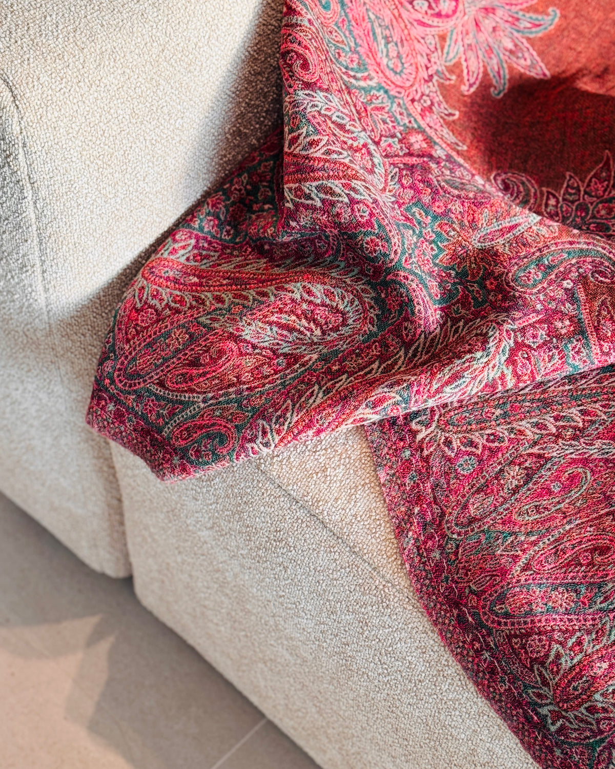 Coperta paisley fucsia e arancio rame che scende dal divano