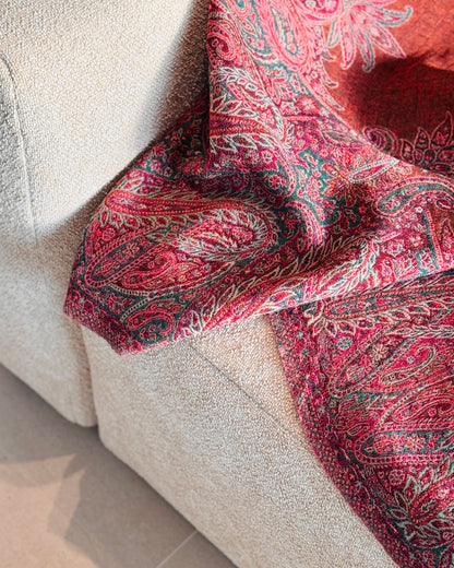 Coperta paisley fucsia e arancio rame che scende dal divano