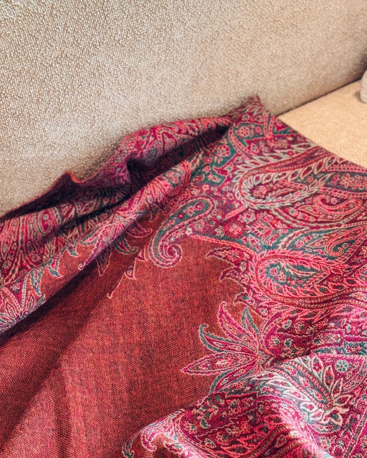 Coperta paisley arancio rame aperta sulla seduta del divano