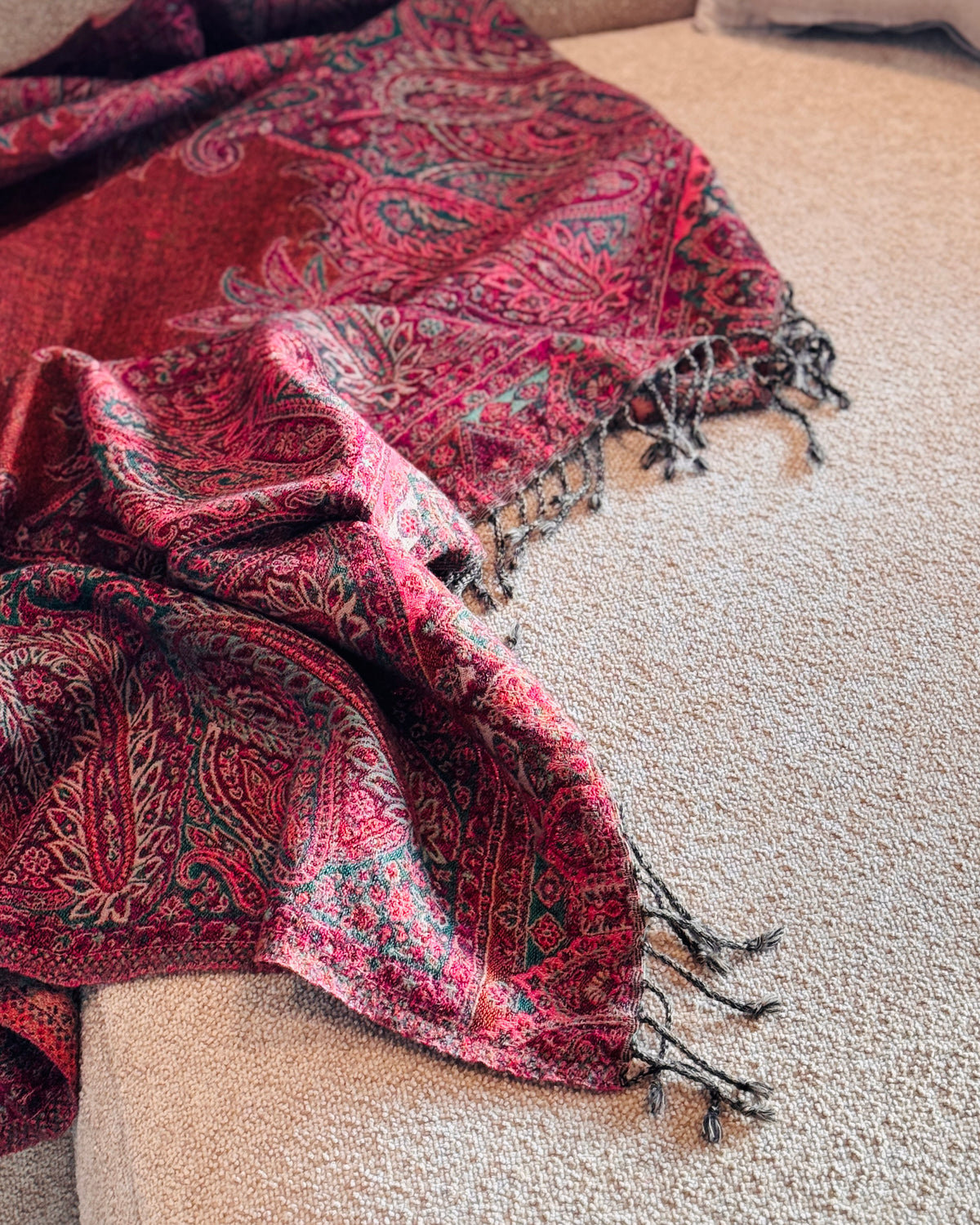 Coperta in lana jacquard paisley sul divano, con frange