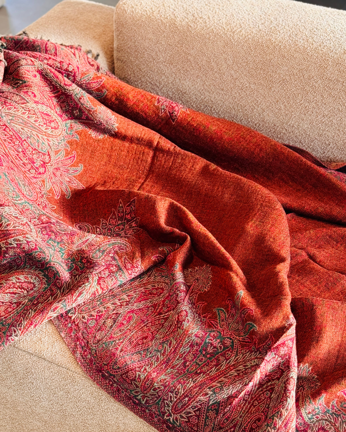 Coperta in lana arancio rame e fucsia aperta sul divano