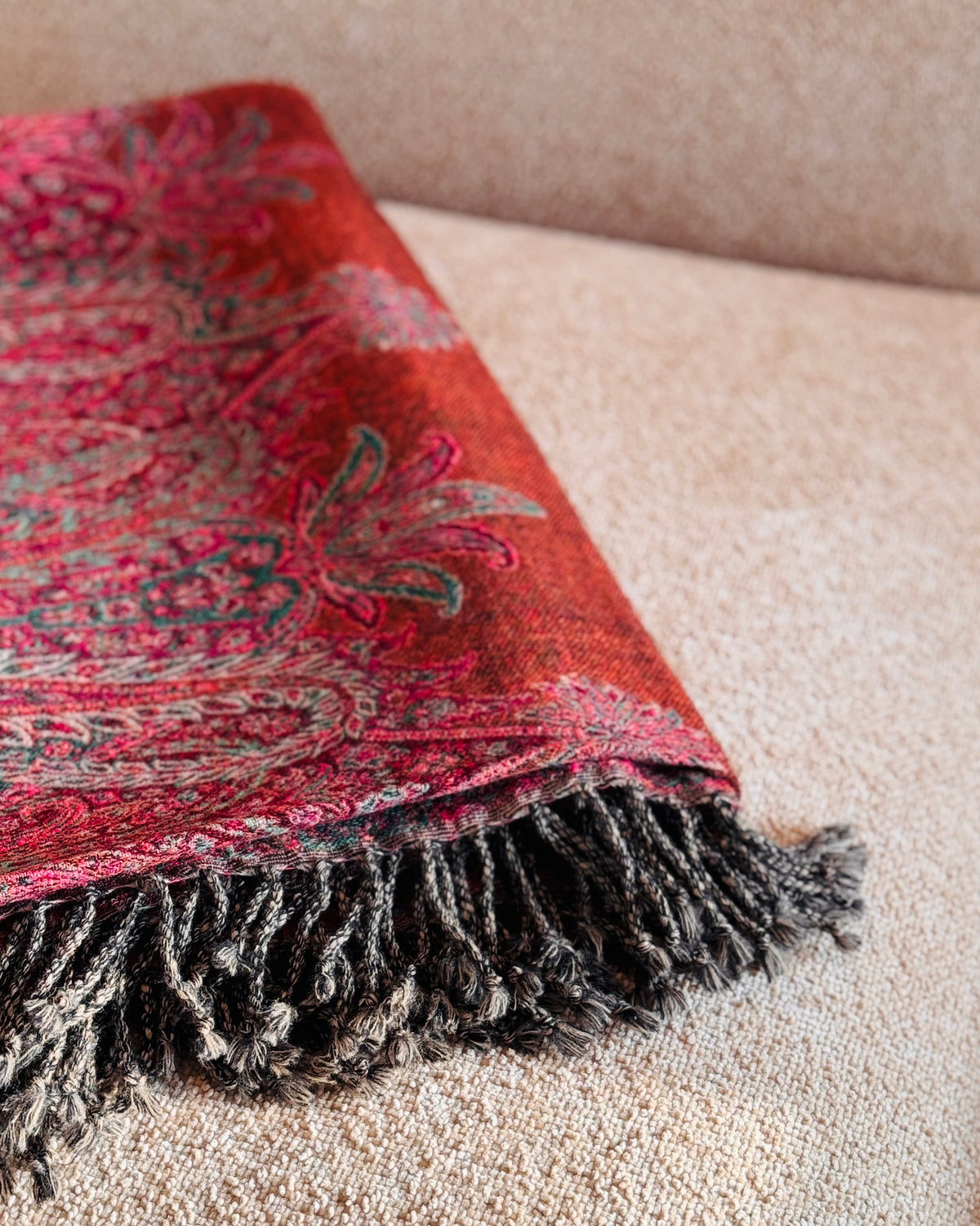 Coperta in lana piegata, bordo paisley rosa fucsia e frange marrone scuro