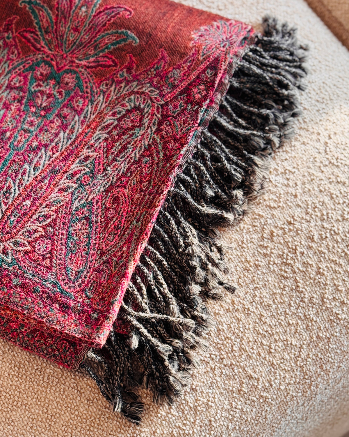 Dettaglio delle frange ritorte marrone scuro della coperta paisley