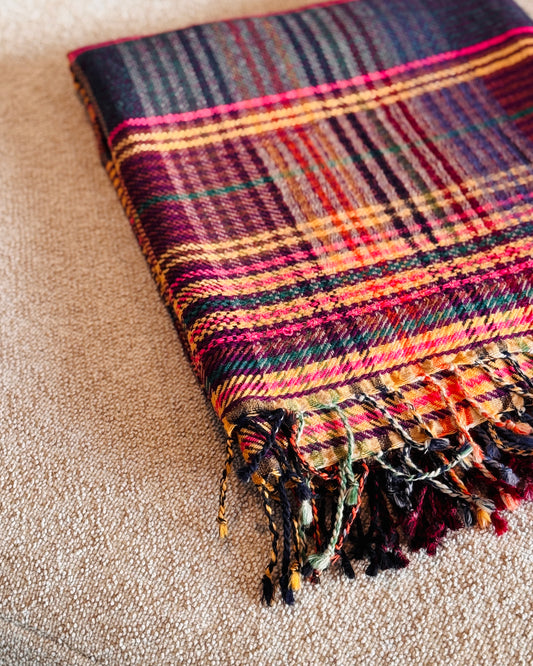 Plaid tartan in lana merino piegato, dettaglio delle frange multicolore