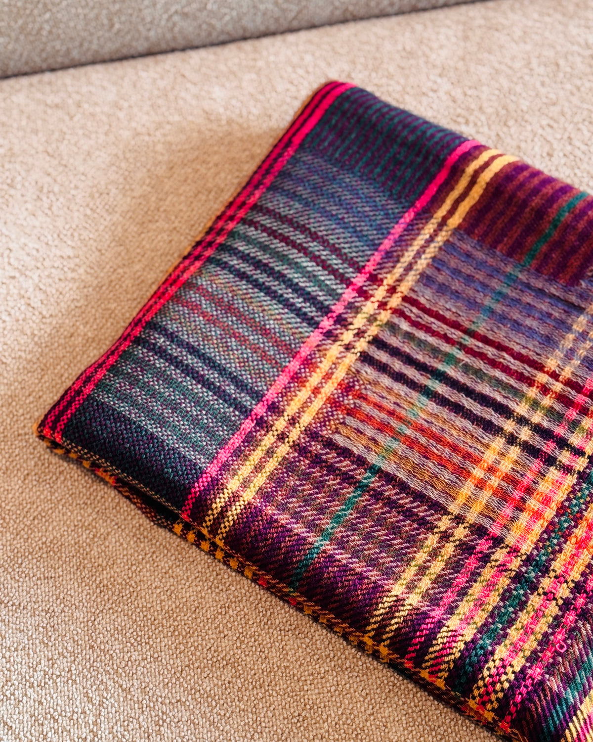 Plaid in lana merino piegato, lato con quadri blu notte e viola