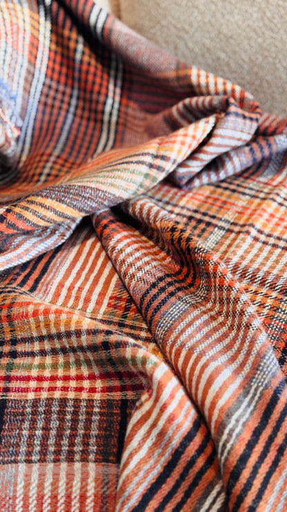 Pieghe del plaid tartan rosso mattone e arancio in lana merino