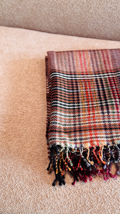 Plaid in lana merino tartan piegato, vista dall'alto con frange