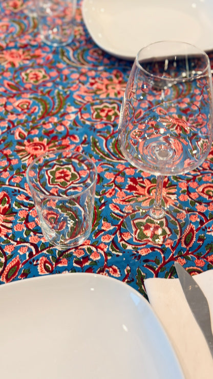 Hand-printed bright turquoise block print cotton tablecloth 150x220cm (60x87 inches): dense floral pattern in coral and red with a striped blue and white border.