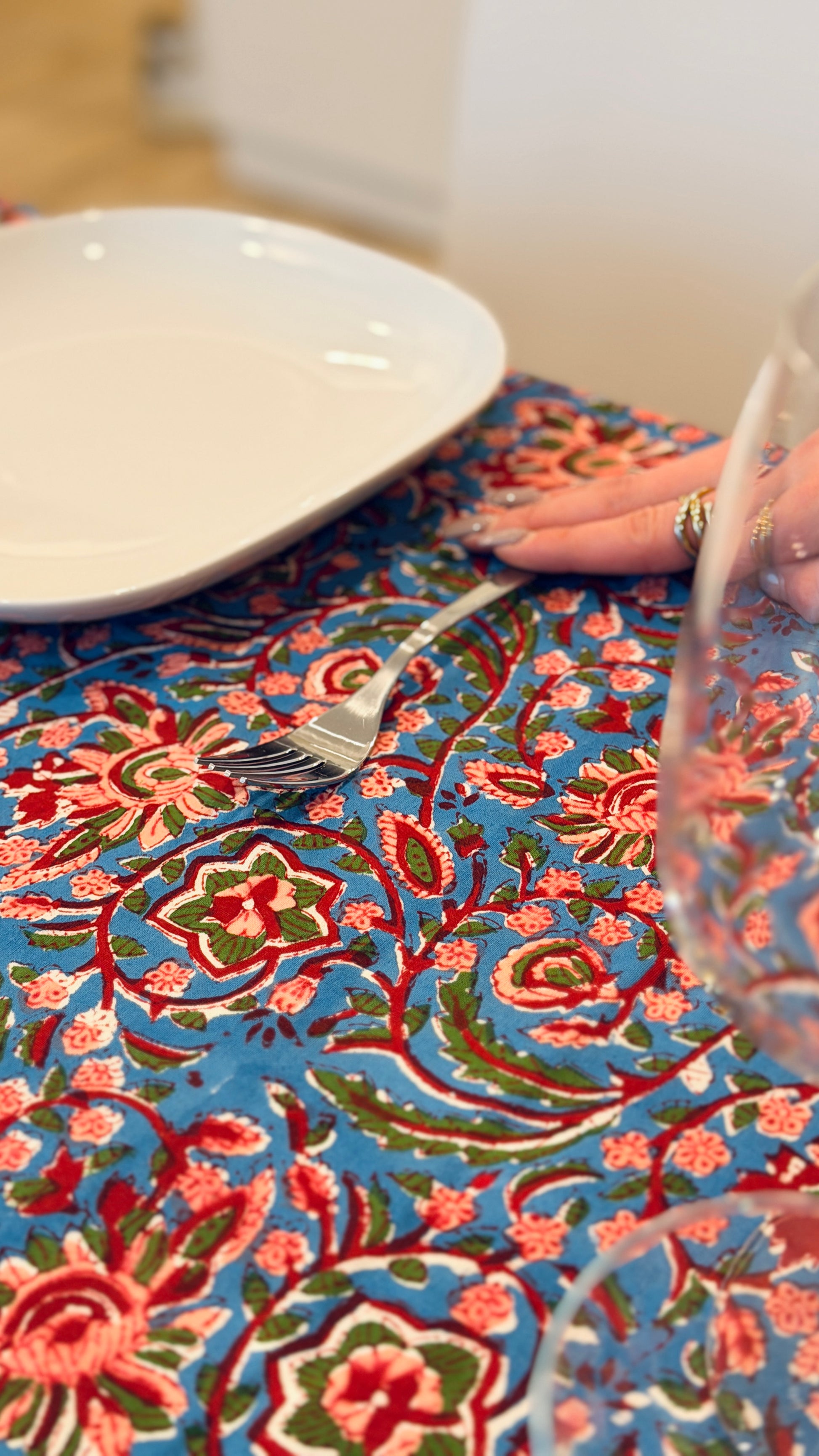 Hand-printed bright turquoise block print cotton tablecloth 150x220cm (60x87 inches): dense floral pattern in coral and red with a striped blue and white border.