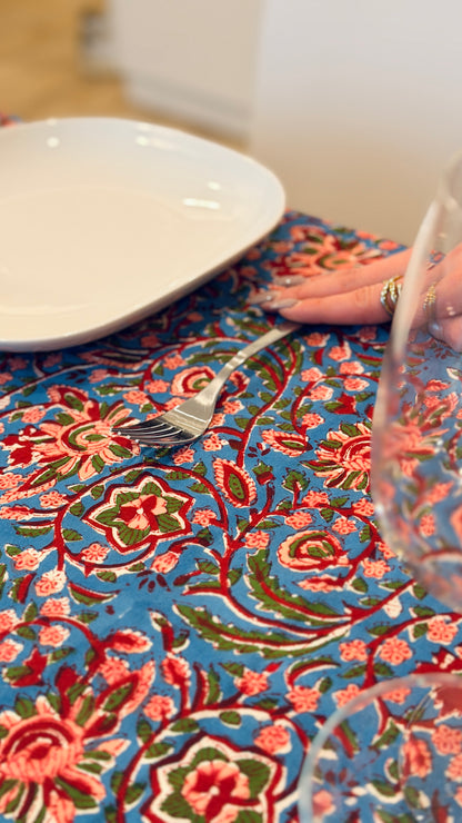 Hand-printed bright turquoise block print cotton tablecloth 150x220cm (60x87 inches): dense floral pattern in coral and red with a striped blue and white border.