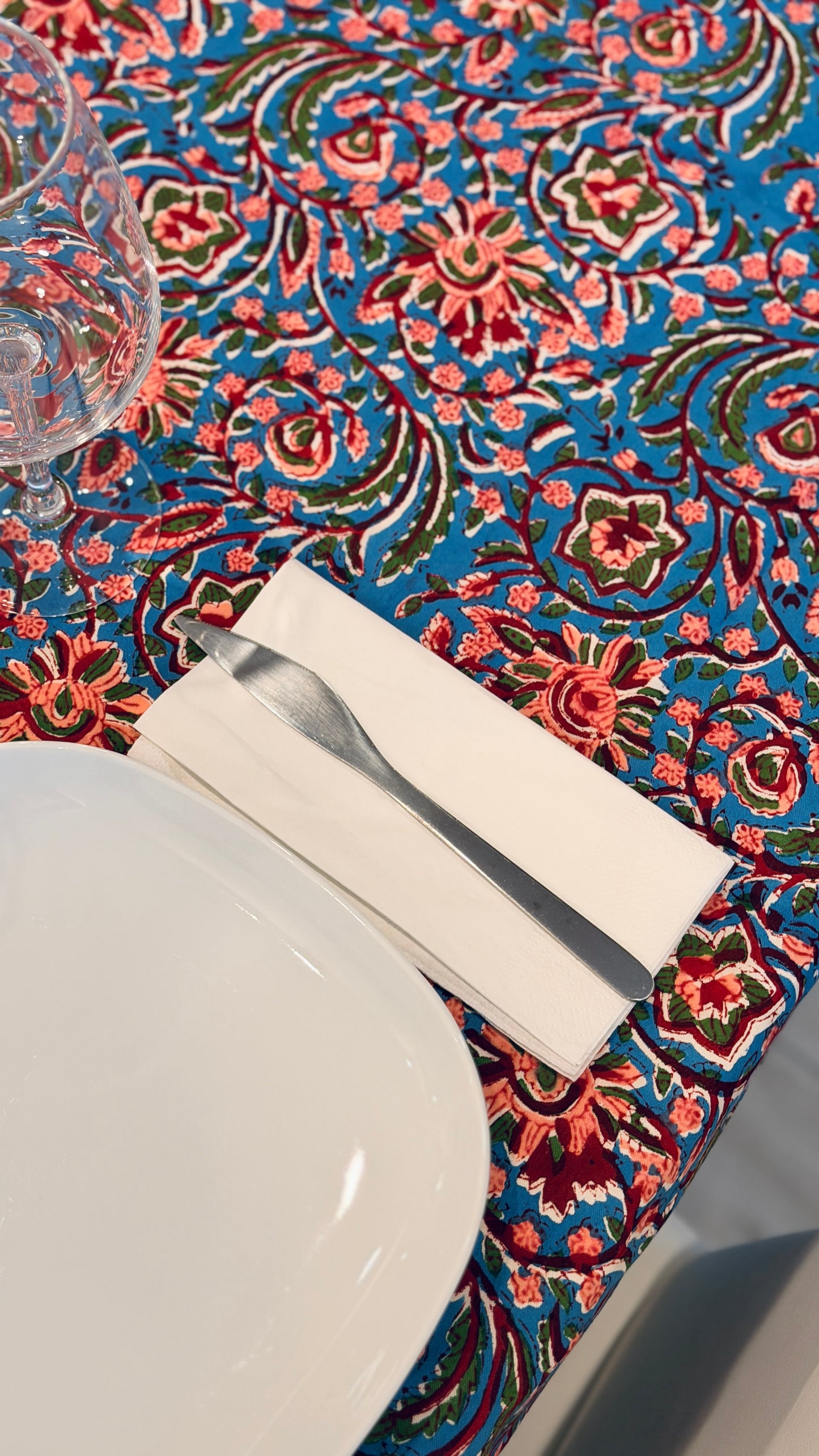 Hand-printed bright turquoise block print cotton tablecloth 150x220cm (60x87 inches): dense floral pattern in coral and red with a striped blue and white border.